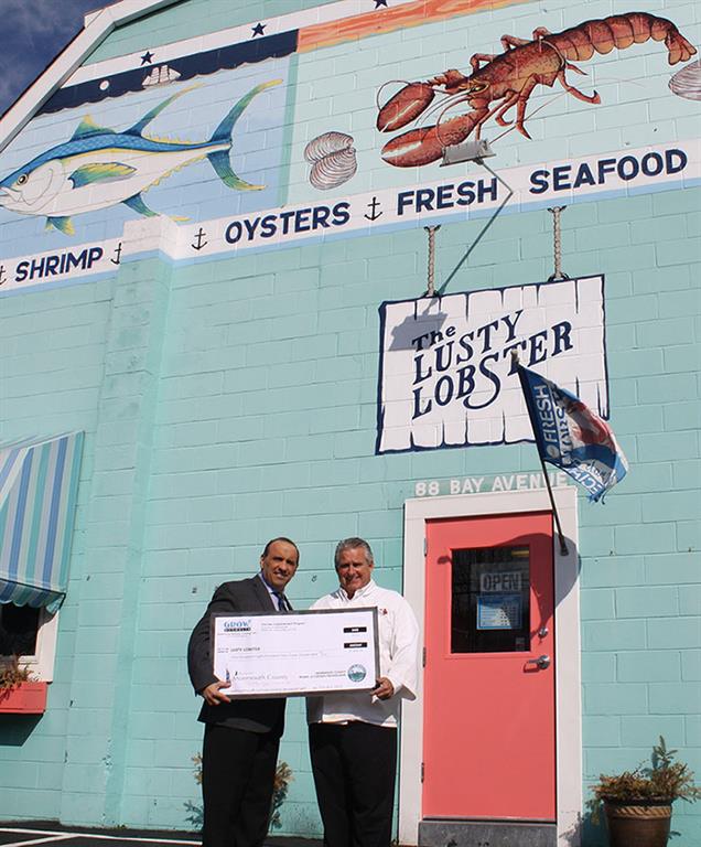 Freeholder Director Thomas A. Arnone presents Lusty Lobster owner Doug Douty with a $1,833 Monmouth County Façade Improvement Program reimbursement check on Feb. 10, 2016 in Highlands, NJ.